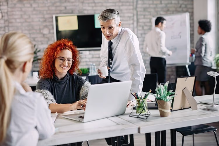 happy-business-people-talking-to-each-other-while-working-in-the-office+(1).webp