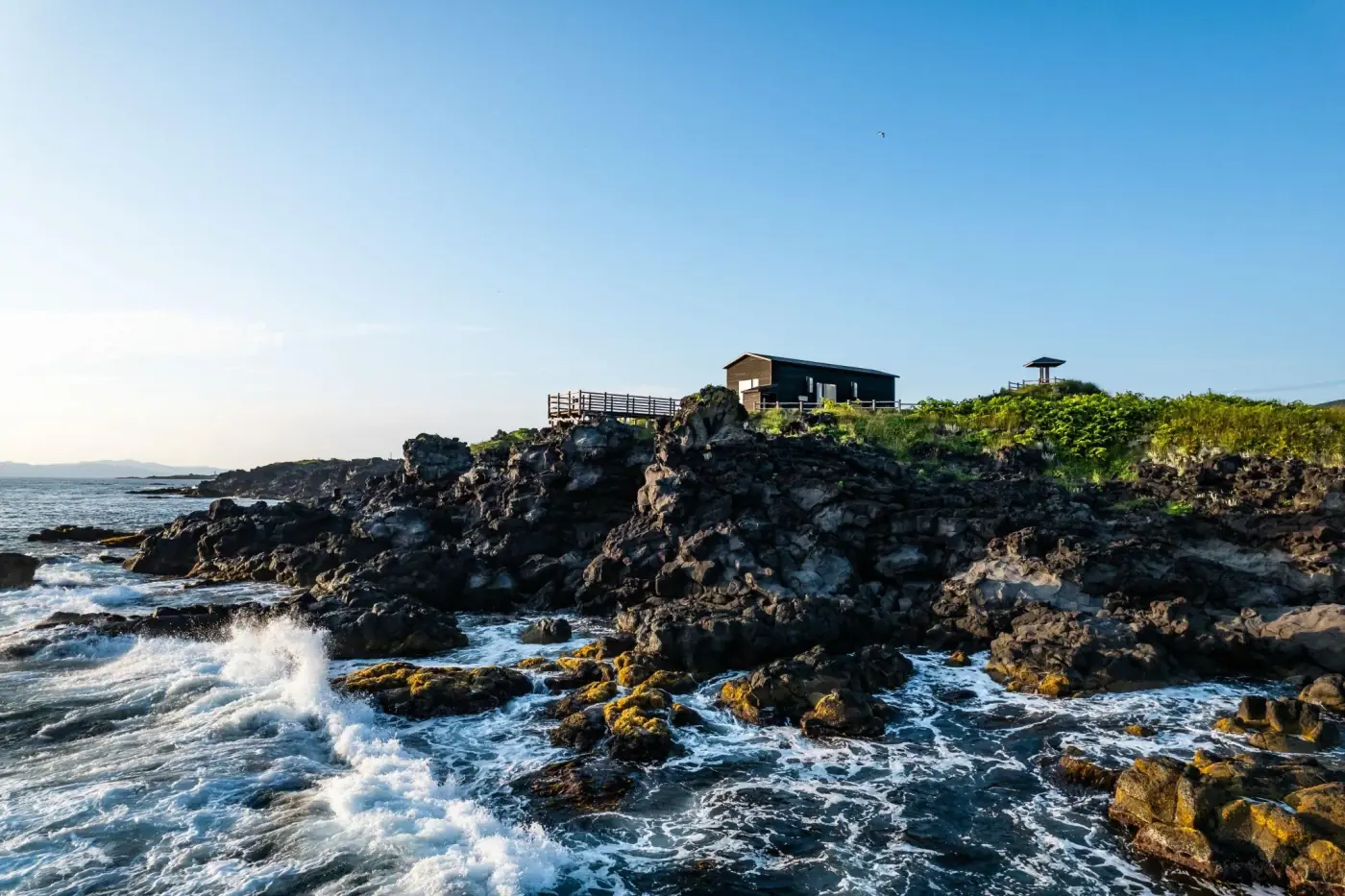 The Kamui Whisky distillery building on the volcanic rock coastline of Rishiri Island, Hokkaido